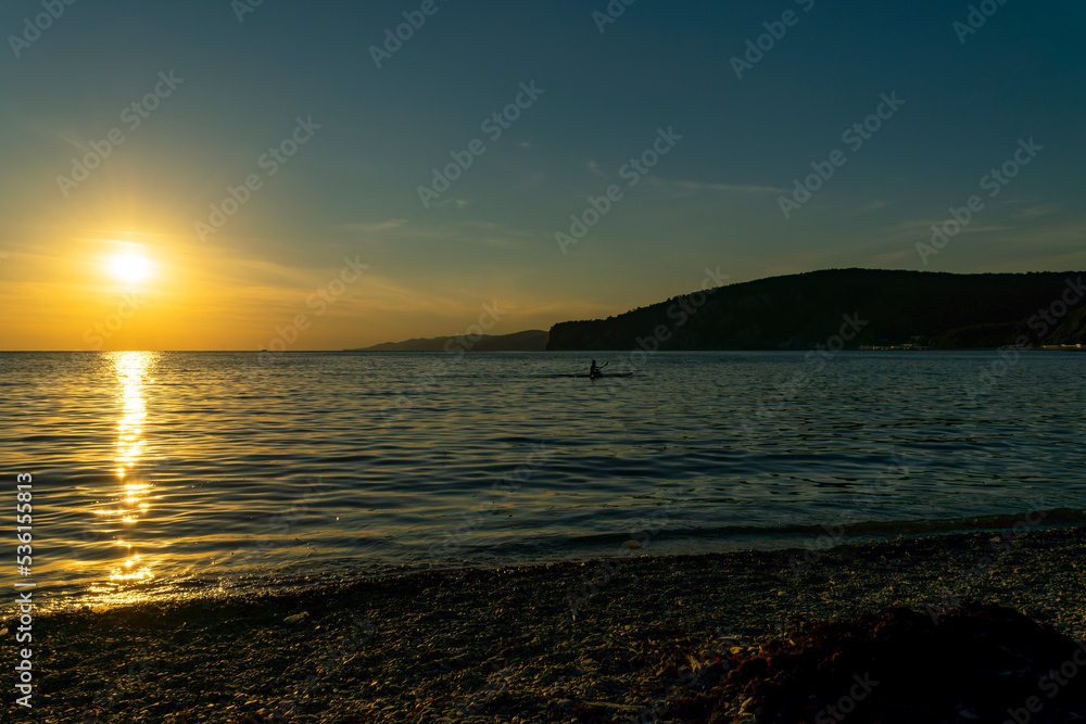 Beautiful sunset over the Black Sea. Bright colors appear on the horizon, while the waves beat against the shore.