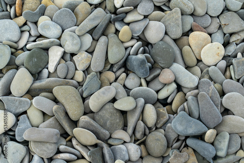 Smooth round pebbles texture background. Pebble sea beach close-up, dark wet pebble and gray dry pebble. High quality photo