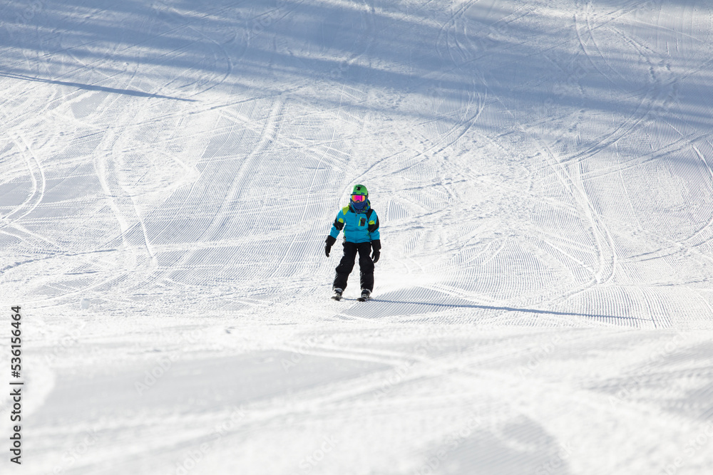 A child while skiing in a ski resort.
