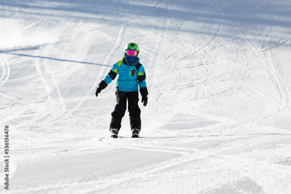 A child while skiing in a ski resort.