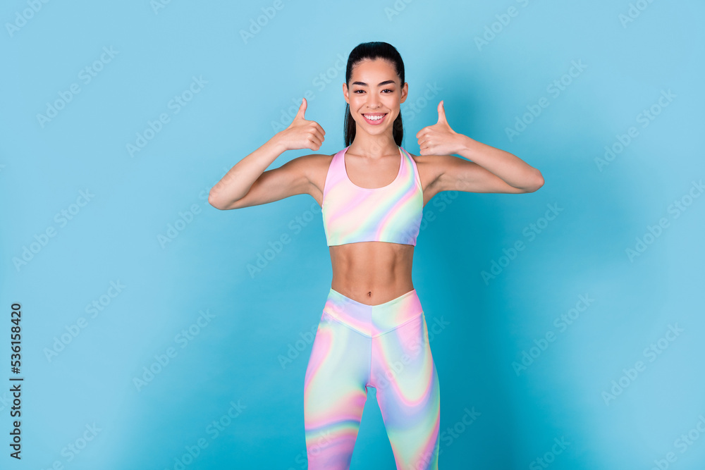 Photo positive coach lady make thumb up fine advice wear rainbow print top leggings pants isolated blue color background Photo positive coach lady make thumb up fine advice wear rainbow print top leggings pants isolated blue color background