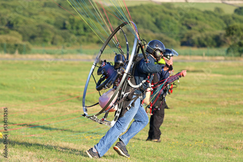Paramotor pilot taking off in a field