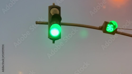 Green traffic signal turned on with a cloudy sky in the background