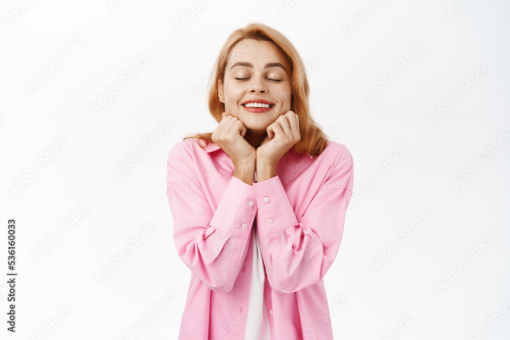Portrait of smiling romantic girl daydreaming, close eyes and dreaming, fantasizing, standing over white background Portrait of smiling romantic girl daydreaming, close eyes and dreaming, fantasizing, standing over white background