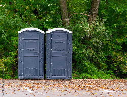 two grey public toilets in the park