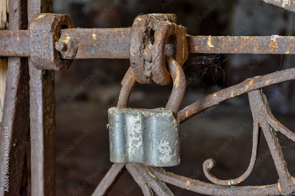 Rusty Chain Locked On Metallic Gate Against Abandoned Building Rusty Chain Locked On Metallic Gate Against Abandoned Building