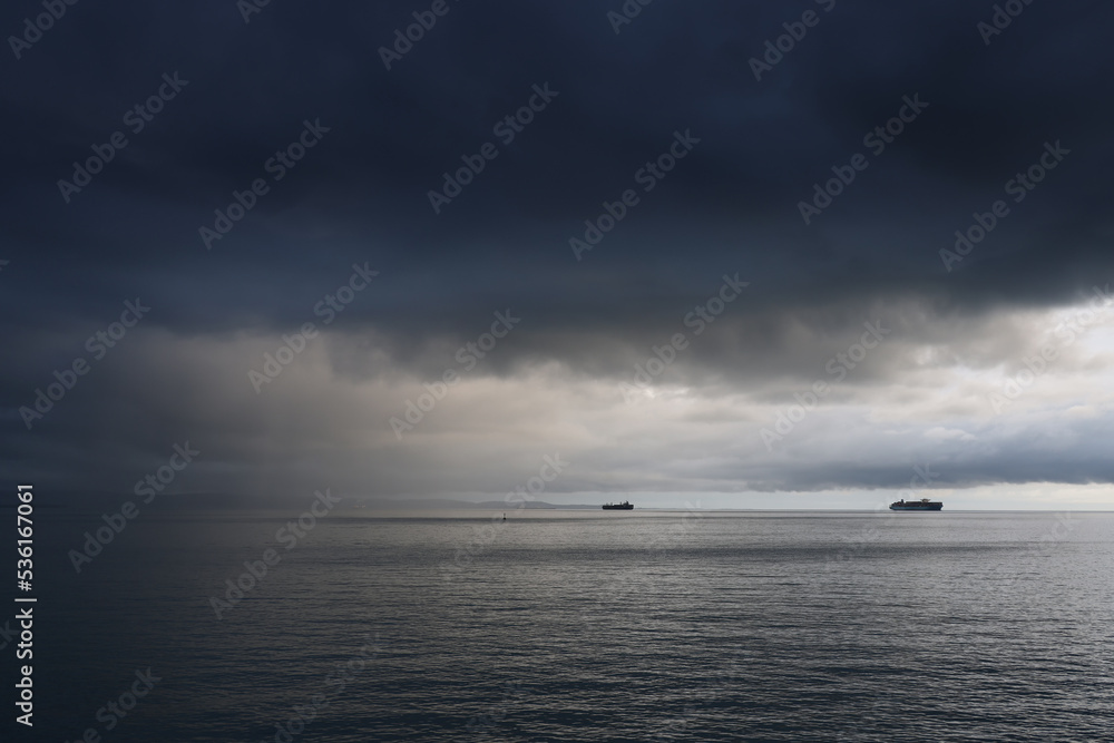 Commercial ships on the sea against the stormy sky Commercial ships on the sea against the stormy sky