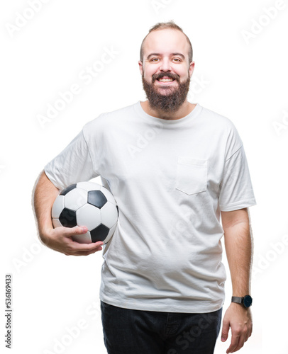 Young caucasian hipster man holding soccer football ball over isolated background with a happy face standing and smiling with a confident smile showing teeth © Krakenimages.com