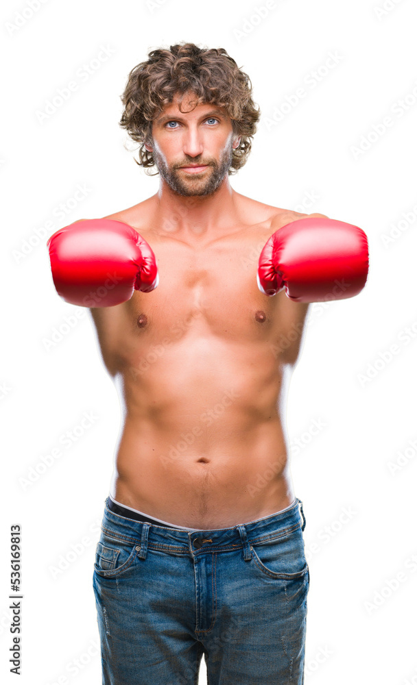 Handsome hispanic boxer man wearing boxing gloves over isolated background with serious expression on face. Simple and natural looking at the camera.