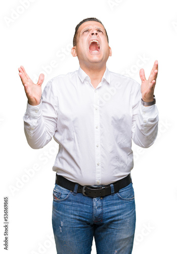 Middle age arab elegant man over isolated background crazy and mad shouting and yelling with aggressive expression and arms raised. Frustration concept.