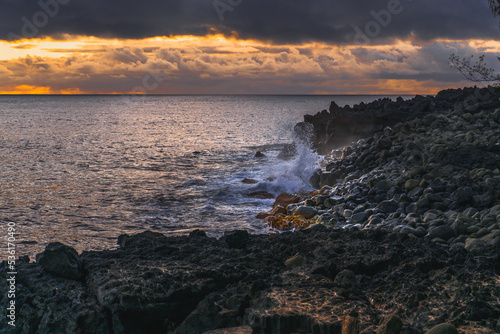 A cloudy sunrise over a rocky ocean shore