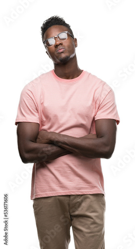 Young african american man wearing pink t-shirt skeptic and nervous, disapproving expression on face with crossed arms. Negative person.