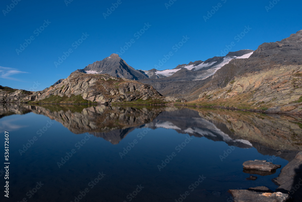 the peaceful waters of the white lake facing the majestic summit of the Dent Parrachee in the heart of the French Alps
