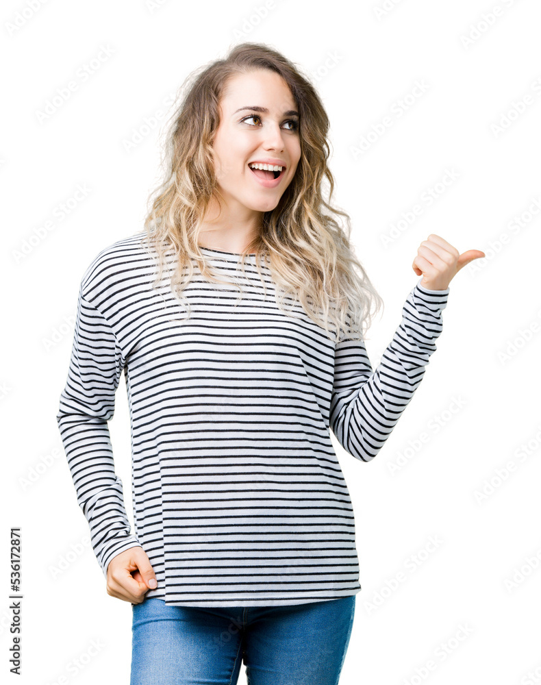 Obraz premium Beautiful young blonde woman wearing stripes sweater over isolated background smiling with happy face looking and pointing to the side with thumb up.