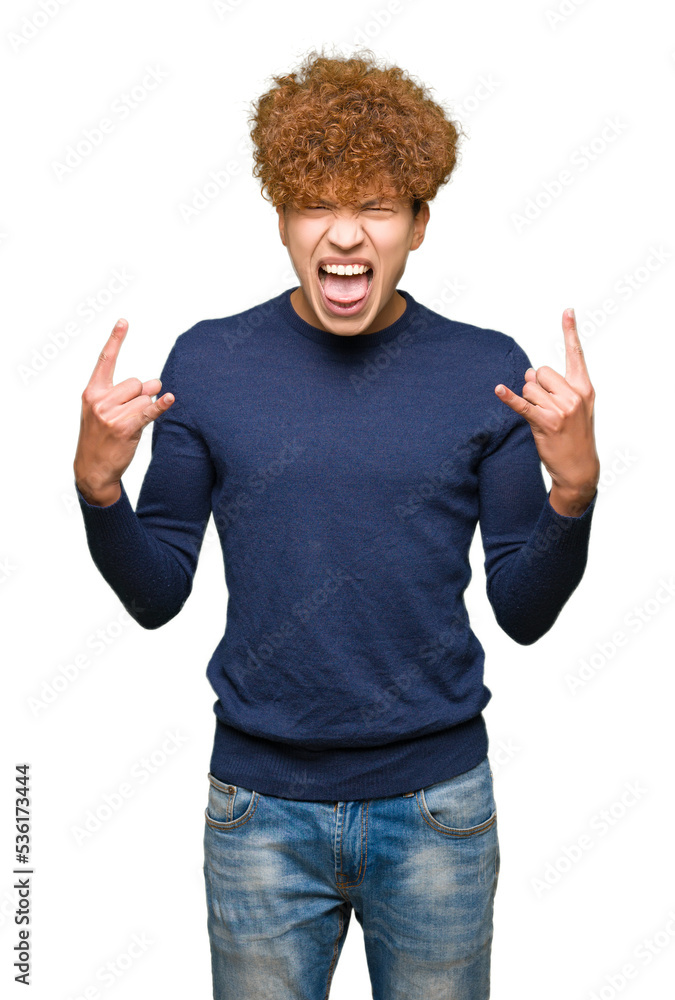 Young handsome man with afro hair shouting with crazy expression doing rock symbol with hands up. Music star. Heavy concept. Young handsome man with afro hair shouting with crazy expression doing rock symbol with hands up. Music star. Heavy concept.