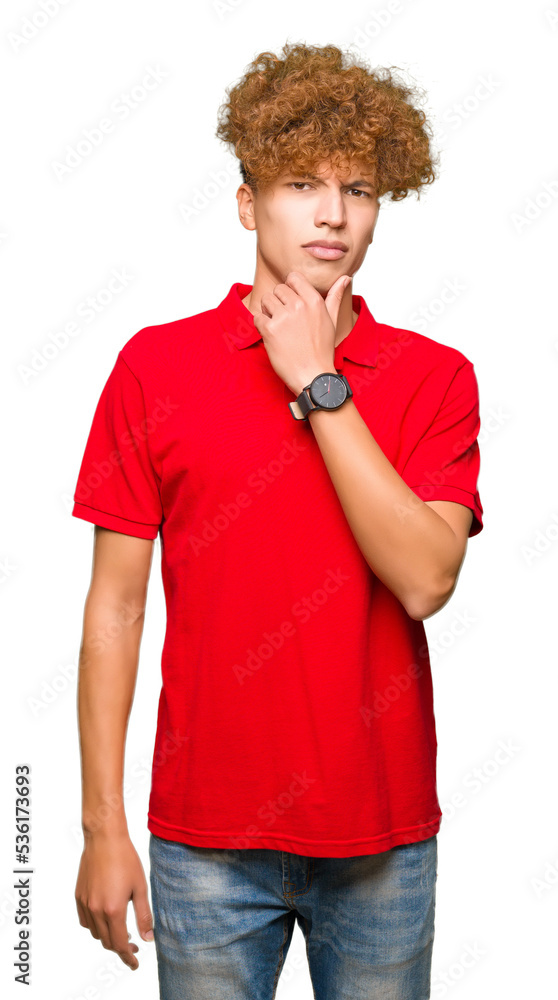 Young handsome man with afro hair wearing red t-shirt looking confident at the camera with smile with crossed arms and hand raised on chin. Thinking positive. Young handsome man with afro hair wearing red t-shirt looking confident at the camera with smile with crossed arms and hand raised on chin. Thinking positive.