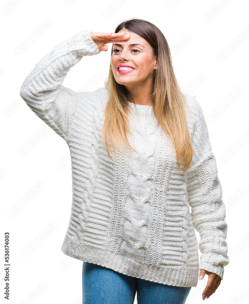 Young beautiful woman casual white sweater over isolated background very happy and smiling looking far away with hand over head. Searching concept. Young beautiful woman casual white sweater over isolated background very happy and smiling looking far away with hand over head. Searching concept.