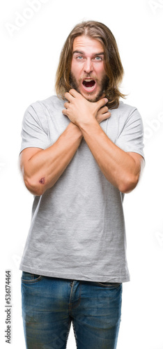 Young handsome man with long hair over isolated background shouting and suffocate because painful strangle. Health problem. Asphyxiate and suicide concept.