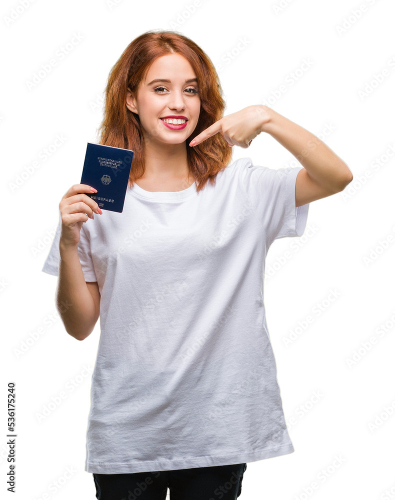 Young beautiful woman holding passport of germany over isolated background very happy pointing with hand and finger Young beautiful woman holding passport of germany over isolated background very happy pointing with hand and finger