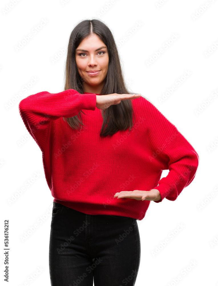 Young beautiful hispanic wearing red sweater gesturing with hands showing big and large size sign, measure symbol. Smiling looking at the camera. Measuring concept. Young beautiful hispanic wearing red sweater gesturing with hands showing big and large size sign, measure symbol. Smiling looking at the camera. Measuring concept.