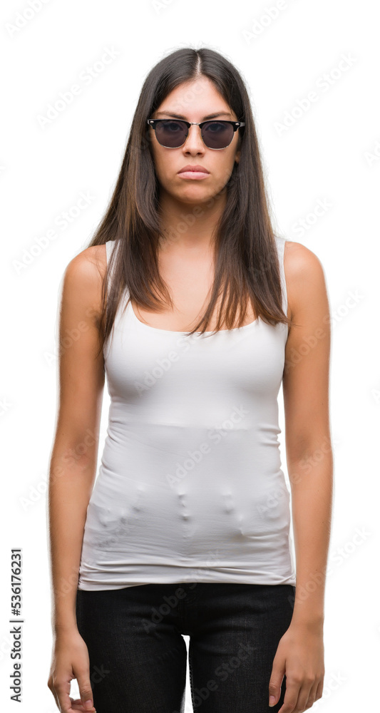 Young beautiful hispanic wearing sunglasses with serious expression on face. Simple and natural looking at the camera. Young beautiful hispanic wearing sunglasses with serious expression on face. Simple and natural looking at the camera.