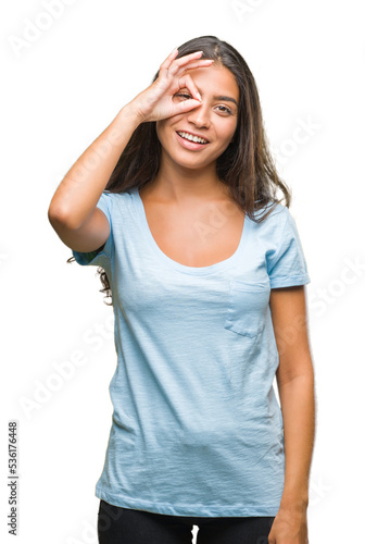 Young beautiful arab woman over isolated background doing ok gesture with hand smiling, eye looking through fingers with happy face.