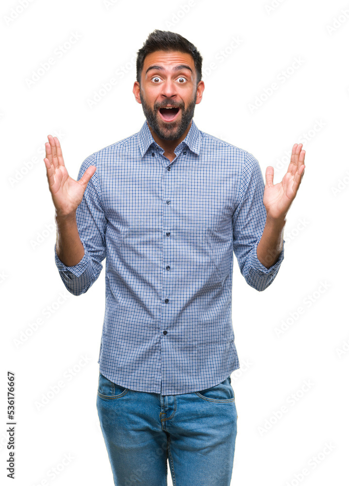 Adult hispanic man over isolated background celebrating crazy and amazed for success with arms raised and open eyes screaming excited. Winner concept Adult hispanic man over isolated background celebrating crazy and amazed for success with arms raised and open eyes screaming excited. Winner concept
