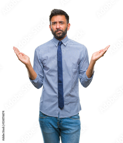Fotografie Adult hispanic business man over isolated background clueless and confused expression with arms and hands raised