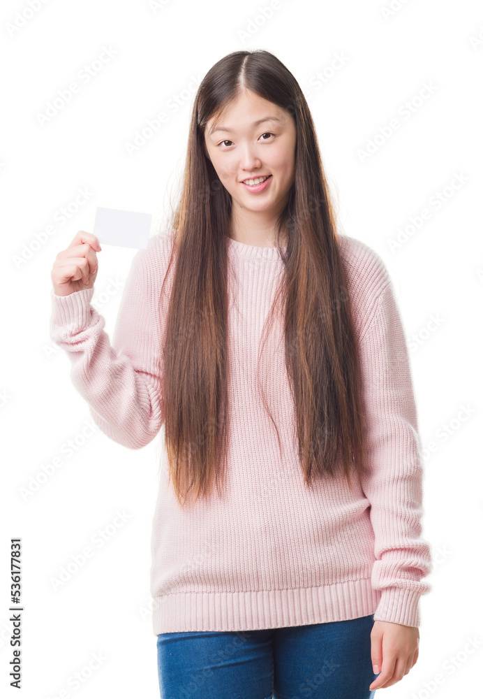 Young Chinese woman over isolated background holding visit card with a happy face standing and smiling with a confident smile showing teeth Young Chinese woman over isolated background holding visit card with a happy face standing and smiling with a confident smile showing teeth
