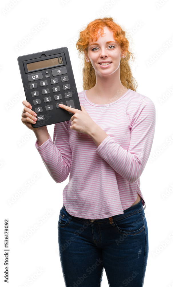 Young redhead woman holding big calculator with a happy face standing and smiling with a confident smile showing teeth Young redhead woman holding big calculator with a happy face standing and smiling with a confident smile showing teeth