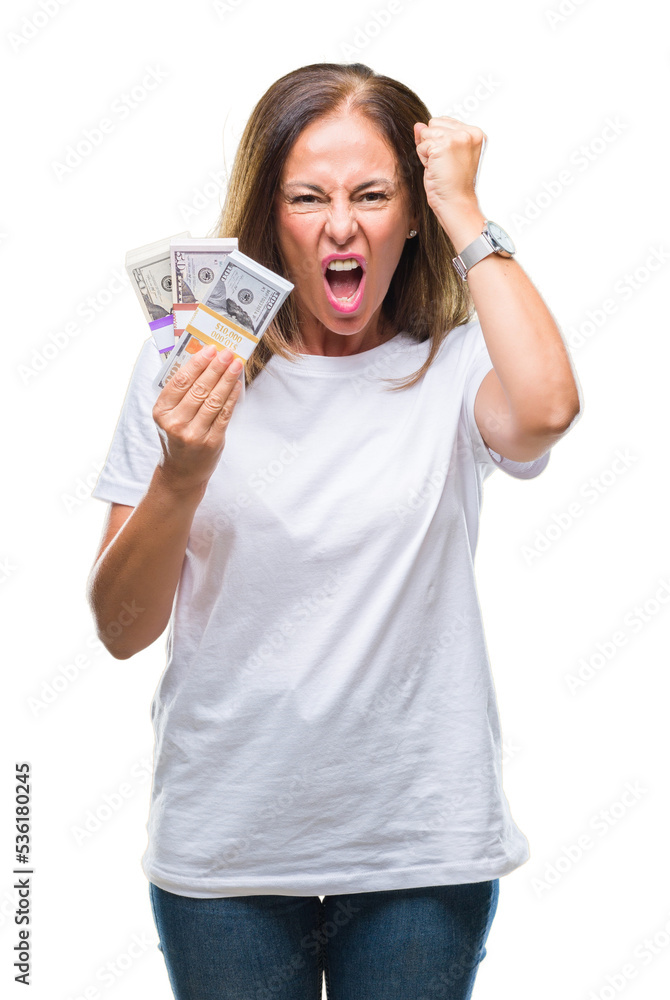 Middle age hispanic woman holding bunch of dollars over isolated background annoyed and frustrated shouting with anger, crazy and yelling with raised hand, anger concept Middle age hispanic woman holding bunch of dollars over isolated background annoyed and frustrated shouting with anger, crazy and yelling with raised hand, anger concept