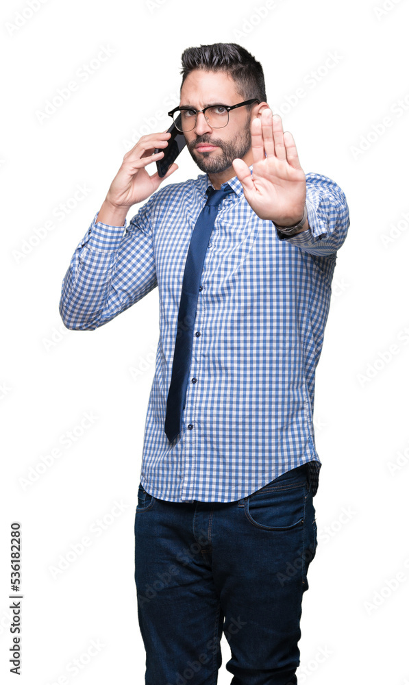 Young business man talking on the phone over isolated background with open hand doing stop sign with serious and confident expression, defense gesture Young business man talking on the phone over isolated background with open hand doing stop sign with serious and confident expression, defense gesture