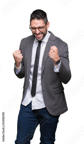 Young handsome business man over isolated background very happy and excited doing winner gesture with arms raised, smiling and screaming for success. Celebration concept.