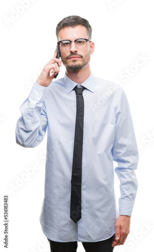 Young business adult man talking on the phone with a confident expression on smart face thinking serious