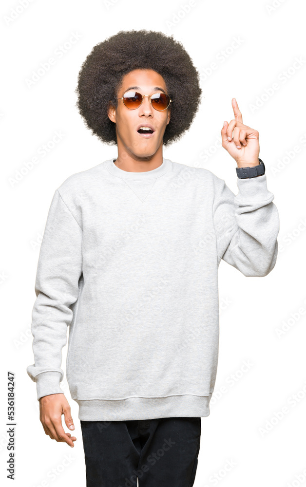 Young african american man with afro hair wearing sunglasses pointing finger up with successful idea. Exited and happy. Number one. Young african american man with afro hair wearing sunglasses pointing finger up with successful idea. Exited and happy. Number one.
