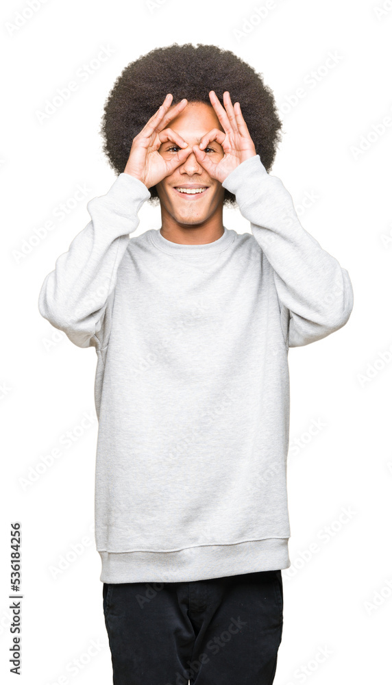 Young african american man with afro hair wearing sporty sweatshirt doing ok gesture like binoculars sticking tongue out, eyes looking through fingers. Crazy expression. Young african american man with afro hair wearing sporty sweatshirt doing ok gesture like binoculars sticking tongue out, eyes looking through fingers. Crazy expression.