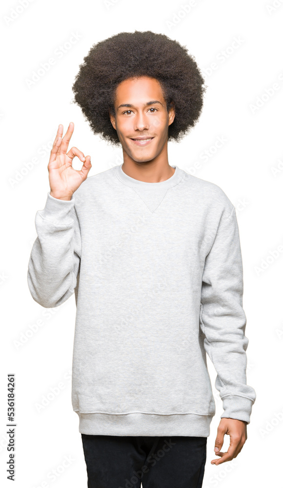 Young african american man with afro hair wearing sporty sweatshirt smiling positive doing ok sign with hand and fingers. Successful expression. Young african american man with afro hair wearing sporty sweatshirt smiling positive doing ok sign with hand and fingers. Successful expression.