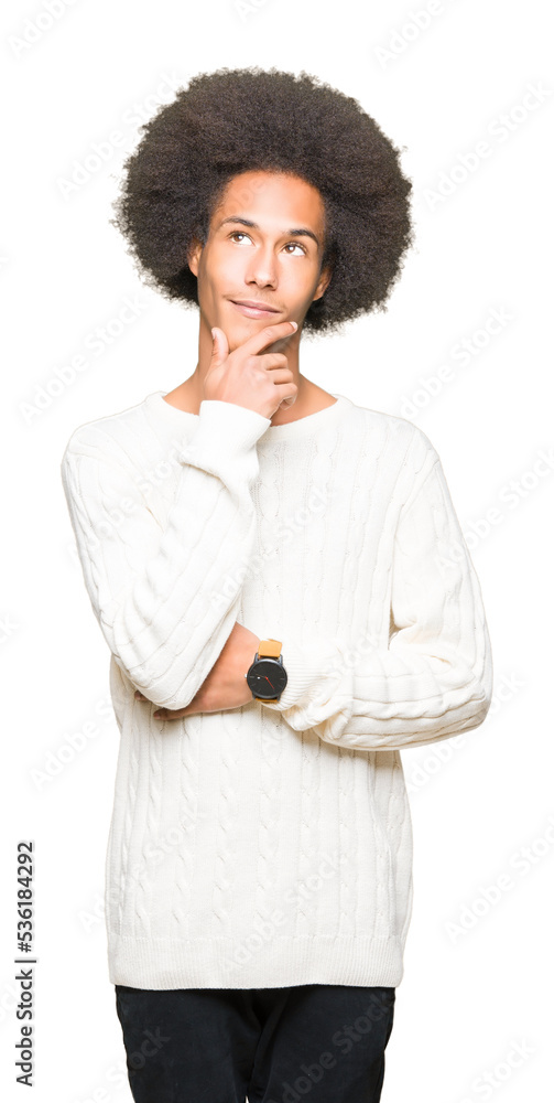 Young african american man with afro hair wearing winter sweater with hand on chin thinking about question, pensive expression. Smiling with thoughtful face. Doubt concept. Young african american man with afro hair wearing winter sweater with hand on chin thinking about question, pensive expression. Smiling with thoughtful face. Doubt concept.