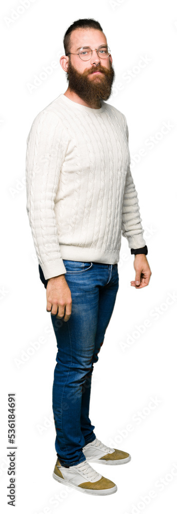 Young hipster man wearing glasses and winter sweater with serious expression on face. Simple and natural looking at the camera. Young hipster man wearing glasses and winter sweater with serious expression on face. Simple and natural looking at the camera.