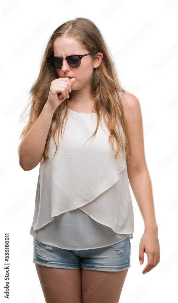 Young blonde woman wearing sunglasses feeling unwell and coughing as symptom for cold or bronchitis. Healthcare concept. Young blonde woman wearing sunglasses feeling unwell and coughing as symptom for cold or bronchitis. Healthcare concept.