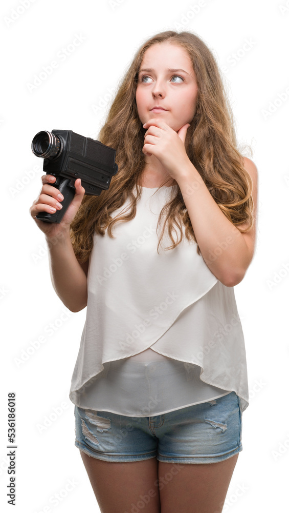 Young blonde woman holding super 8 video camera serious face thinking about question, very confused idea Young blonde woman holding super 8 video camera serious face thinking about question, very confused idea