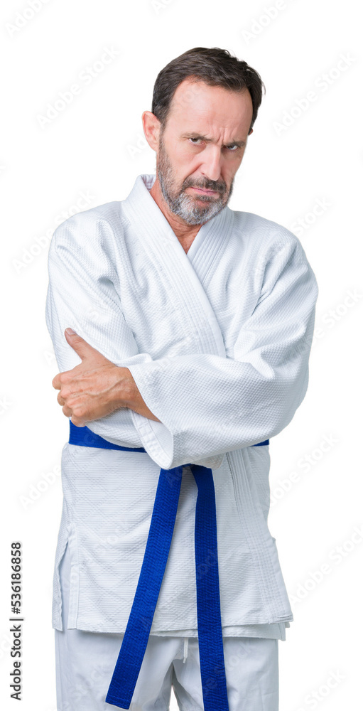Handsome middle age senior man wearing kimono uniform over isolated background skeptic and nervous, disapproving expression on face with crossed arms. Negative person. Handsome middle age senior man wearing kimono uniform over isolated background skeptic and nervous, disapproving expression on face with crossed arms. Negative person.