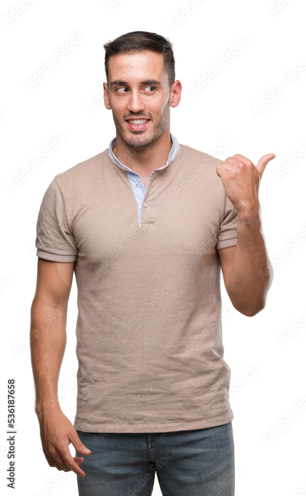 Handsome young man pointing with hand and finger up with happy face smiling Handsome young man pointing with hand and finger up with happy face smiling
