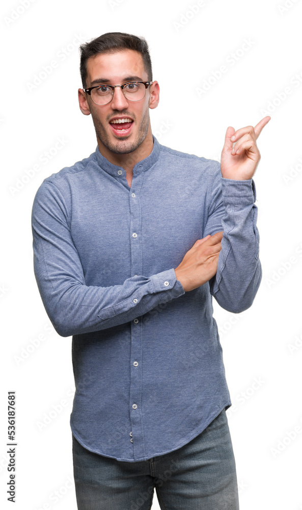 Handsome young elegant man wearing glasses with a big smile on face, pointing with hand and finger to the side looking at the camera. Handsome young elegant man wearing glasses with a big smile on face, pointing with hand and finger to the side looking at the camera.