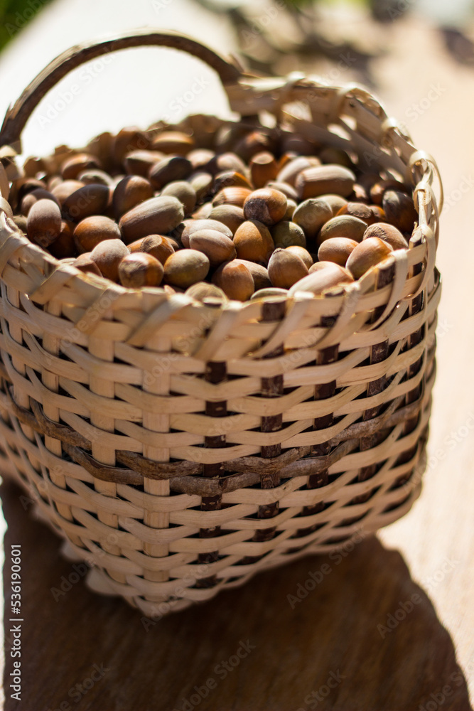 Hazelnuts in a wicker basket on old wooden table