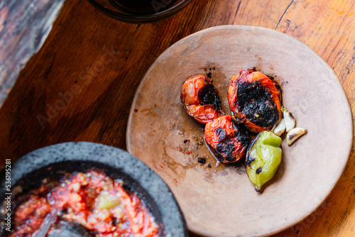 Burnt chiles to prepare molcajete sauce in a rustic kitchen. Gastronomic photography with copy space. photo