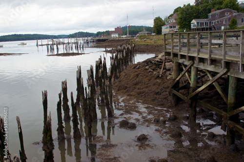 Wiscasset  Maine pier on overcast day in summer showing old houses  boats  rotting timber and ocean