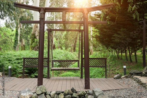 Beautiful brown metal swing in tranquil park