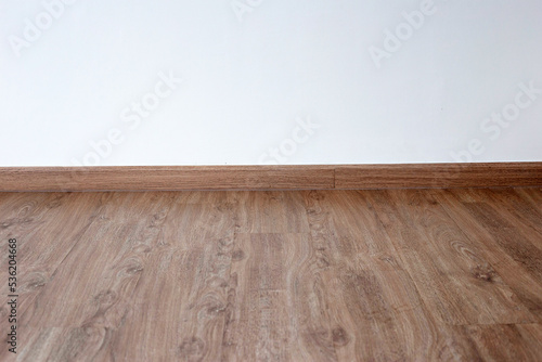 Laminate wood floor with blank white wall © Bowonpat