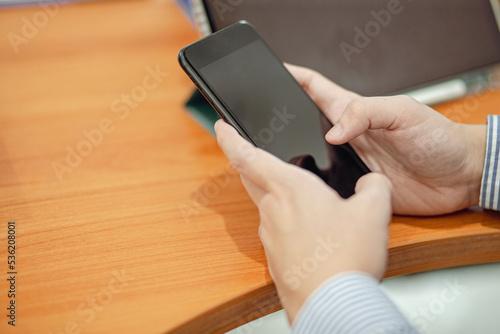 man hand holding smartphone on desk